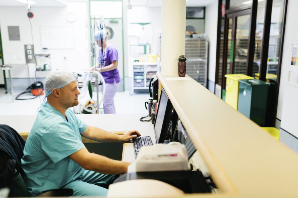 Technician sitting in front of a computer in a hospital.